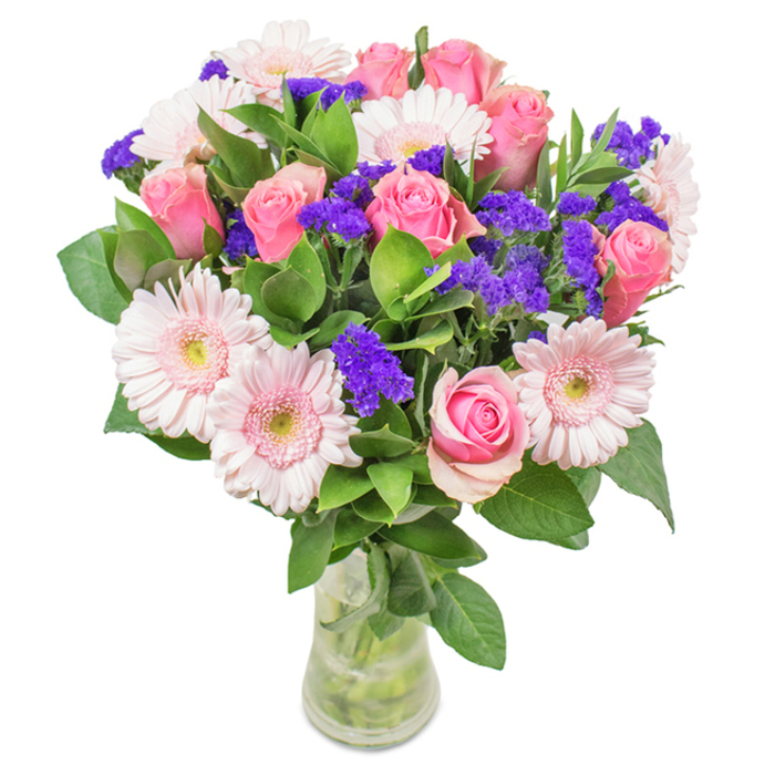 A stunningly arranged bouquet occupies center stage, its pink and purple hues perfectly attuned to the tastes of London's diverse neighbourhoods. The arrangement features approximately 7-9 pink roses-some tightly furled, others opening in classic spiral formation-infusing the bouquet with romantic drama. Around five to seven pale pink gerbera daisies spread their large, round heads, radiating gentle warmth and cheer. Complementing these are clusters of vivid purple statice, offering striking color contrast and airy texture. The composition rests in a clear glass vase, where neatly cut stems and glimmering water accentuate the sense of freshness and authenticity. Deep green foliage underpins the bouquet, bringing a wild yet curated abundance reminiscent of Hampstead's green gardens. Designed with versatility in mind, the bouquet is suitable for birthdays, family celebrations, or as an elegant feature for a City flat, conveying sentiments of affection, celebration, and genuine local charm.